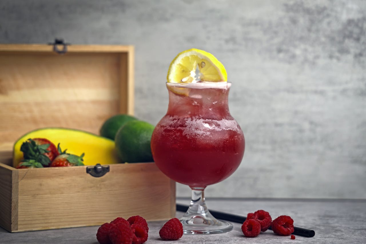 Cool tropical fruit juice with lemon slice, surrounded by fresh fruits, perfect for a healthy lifestyle.