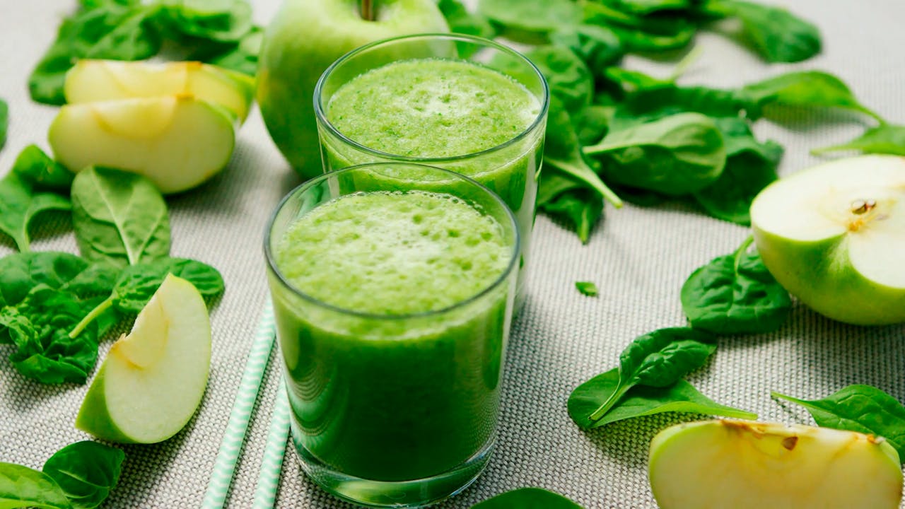 Fresh green smoothie with apples and spinach, perfect for a healthy refreshment.